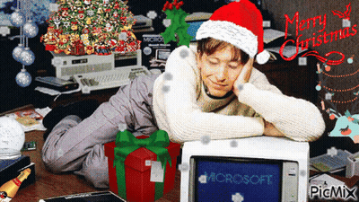 Man In Santa Hat Lying Beside Computer Saying Microsoft GIF