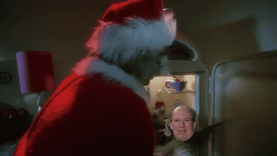 Man In Santa Hat Standing In Front Of Refrigerator GIF