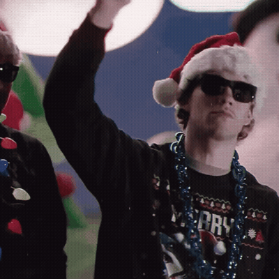 Man In Santa Hat, Sunglasses, And Merry Shirt GIF