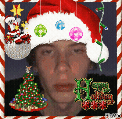 Man In Santa Hat Surrounded By Christmas Decorations And Tree GIF