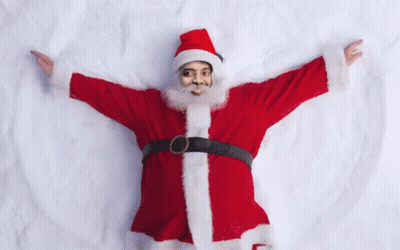 Man In Santa Suit Laying In Snow With Arms Outstretched GIF