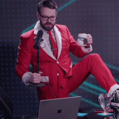 Man In Santa Suit Sitting At Laptop Holding Cup GIF