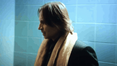 Man In Scarf In Front Of Blue Wall GIF