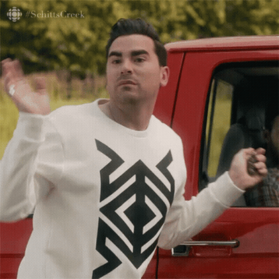 Man In Schitts Creek Sweater In Front Of Red Vehicle GIF