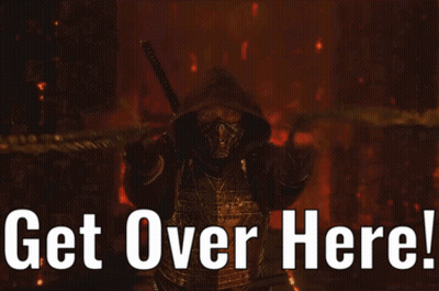 Man In Scorpion Costume Holding Tire Pointing GIF