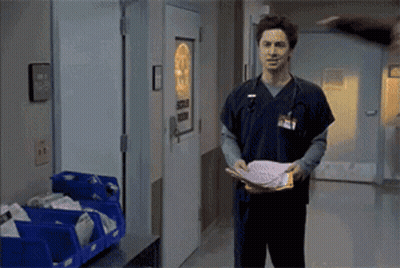 Man In Scrub Top Holding Paper At Surgical Room Door GIF