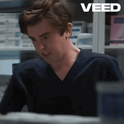 Man In Scrub Top Sitting At Desk Saying Veed GIF