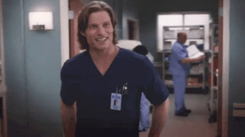 Man In Scrub Top Smiling In Hospital Room GIF