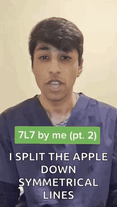 Man In Scrub Top Splitting Apple Along Symmetrical Lines GIF