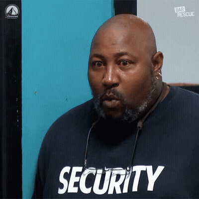 Man In Security Shirt Looking At Camera GIF