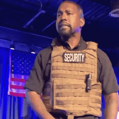 Man In Security Vest Standing On Stage GIF