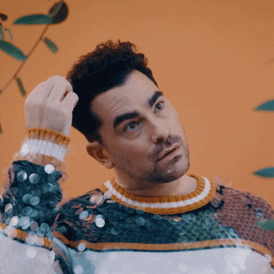 Man In Sequined Sweater Scratching Hair GIF