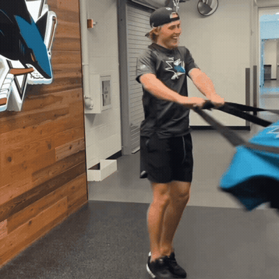 Man In Sharks Shirt Pulling Bag GIF