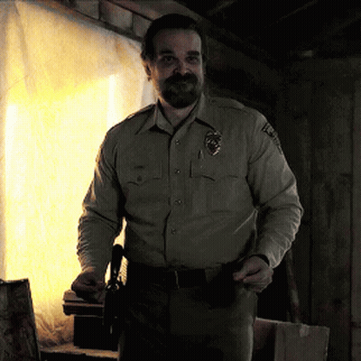 Man In Sheriff Uniform Holding Gun In Pocket GIF
