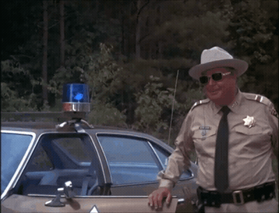 Man In Sheriff Uniform Leaning On Car GIF