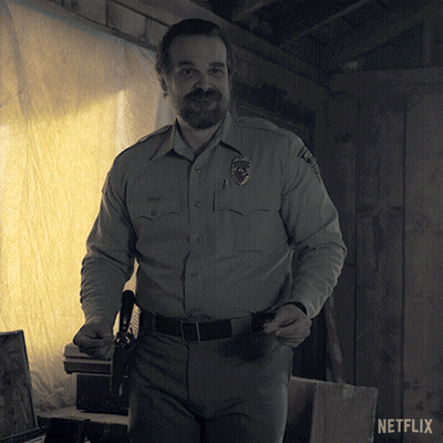 Man In Sheriff Uniform Next To Netflix Logo GIF