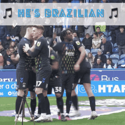 Man In Shirt With Hammer On Back Standing In Front Of Crowd GIF