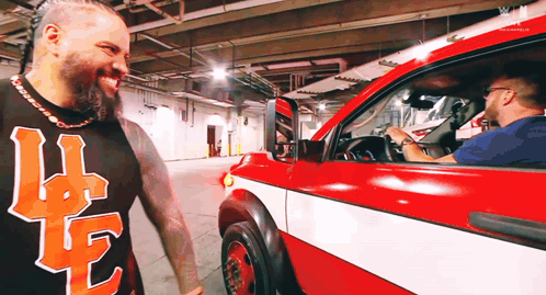 Man In Shirt With Letter L Next To Red Truck GIF