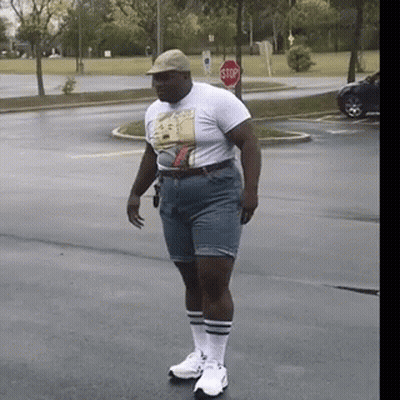 Man In Shorts And T-Shirt With Stop Sign GIF