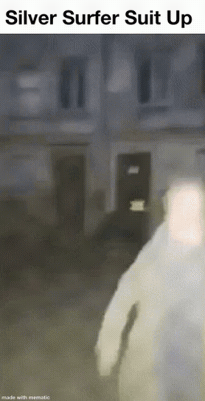 Man In Silver Surfer Suit Walking In Front Of Building GIF