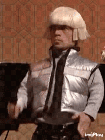 Man In Silver Vest And Blonde Wig GIF