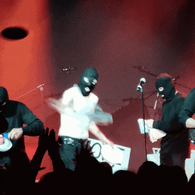 Man In Ski Mask Playing Drums On Stage GIF