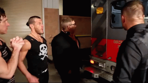 Man In Skull And Crossbones Tank Top In Front Of Fire Truck GIF