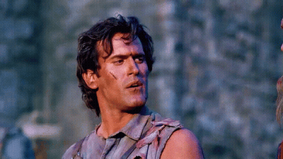 Man In Sleeveless Shirt Holding Gun GIF