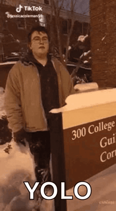Man In Snow Next To YOLO Sign GIF