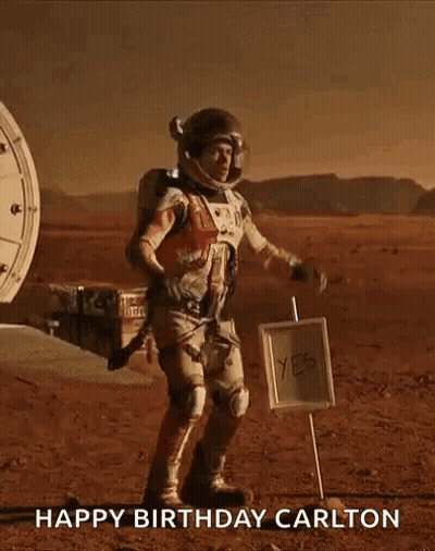 Man In Space Suit On Mars Next To Happy Birthday Carlton Sign GIF