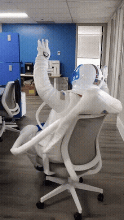 Man In Space Suit Sitting In Chair GIF