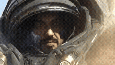 Man In Space Suit With Helmet Looking At Camera GIF