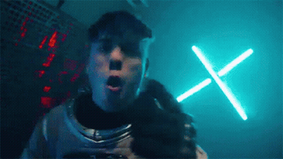 Man In Space Suit With Neon X In Dark Room GIF