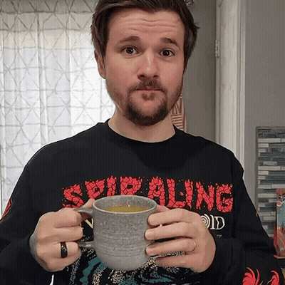 Man In Spiraling Shirt Holding Coffee GIF