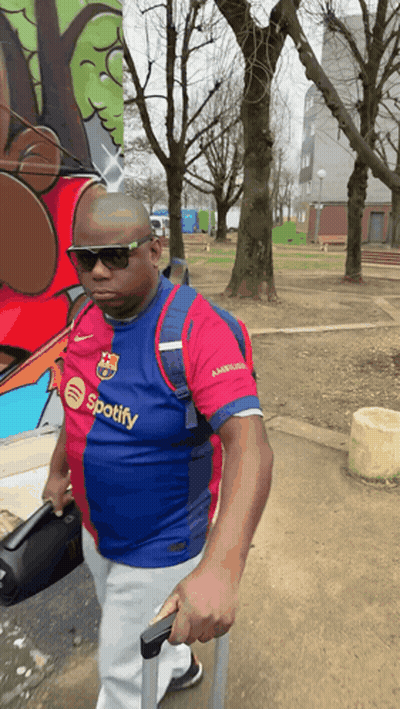 Man In Spotify Shirt Walking With Suitcase GIF