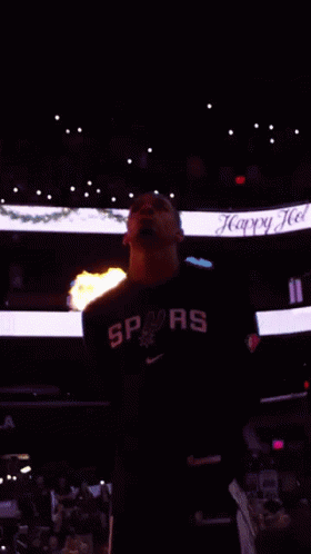 Man In Spurs Shirt In Front Of Flames GIF