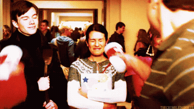 Man In Star Sweater Held By Striped Shirt Man GIF