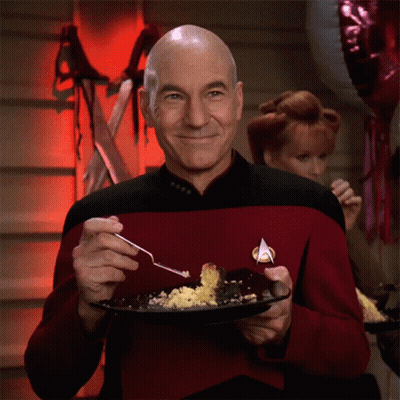 Man In Star Trek Uniform Holding Plate Of Food With Fork GIF