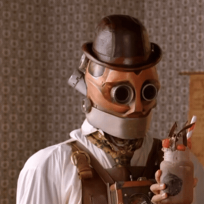 Man In Steampunk Helmet And Goggles Holding Milkshake GIF