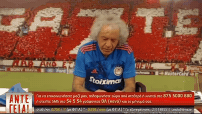 Man In Stoixima Shirt Talking On Phone GIF