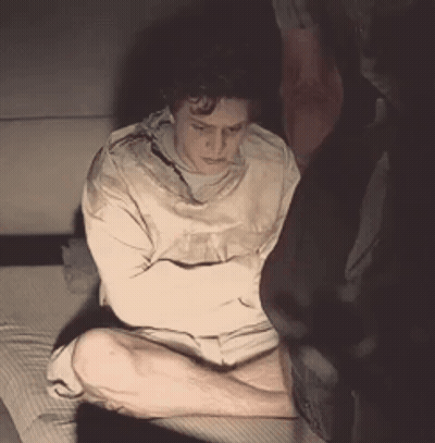 Man In Straight Jacket Sitting With Arms Crossed GIF