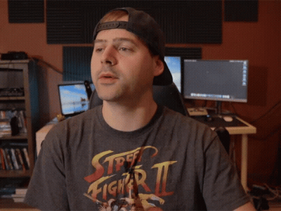 Man In Street Fighter Zero Shirt Holding Something GIF