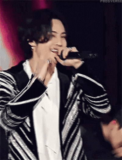 Man In Striped Jacket Singing Into Microphone GIF