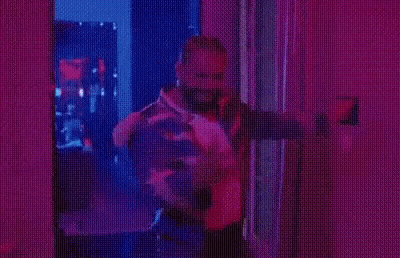 Man In Striped Jacket Under Purple Lights GIF