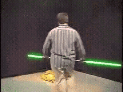 Man In Striped Pajamas Holding Green Lightsabers GIF