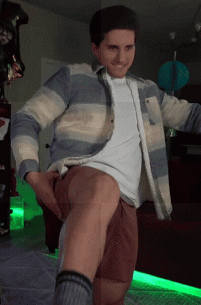 Man In Striped Shirt And Brown Shorts Standing With Leg Up GIF