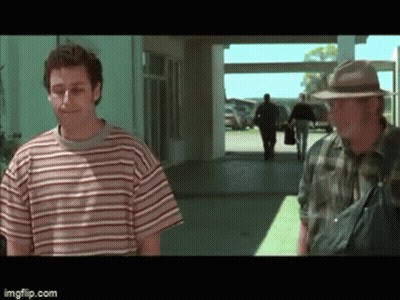 Man In Striped Shirt And Man In Hat Standing In Hallway GIF