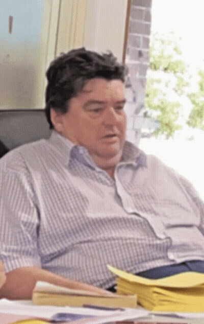 Man In Striped Shirt At Desk With Papers GIF