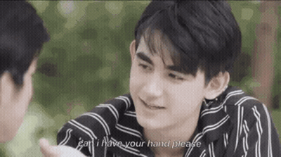 Man In Striped Shirt Holding Another Man's Hand And Talking GIF