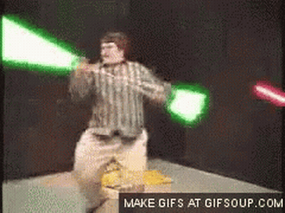 Man In Striped Shirt Holding Green And Red Lightsaber GIF
